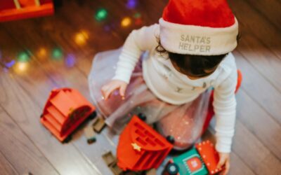 enfant portant un chapeau de Père Noël jouant avec des blocs Lego