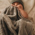 bébé avec un bonnet en tricot gris